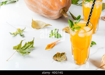 Fall and winter cold cocktails. Spicy pumpkin mojito with fresh mint, on white marble table. copy space Stock Photo