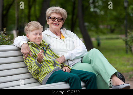 Smiling grandson playing with spinner gadget, happy grandma hugging boy Stock Photo