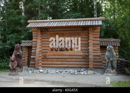 KIVACH, KARELIA, RUSSIA - CIRCA JUN, 2017: Wooden signboard is on the entrance of the Kivach waterfall national park. Brown bears sculptures and inscr Stock Photo