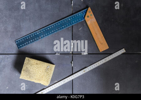 Tiles concept tool, angle, ruler, sponge on tiles top view. Stock Photo