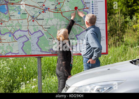 Senior happy couple finding location details on map while traveling by car Stock Photo