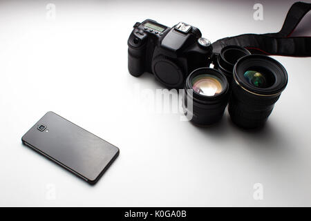 group of camera lenses and a mobile phone on a white background Stock Photo