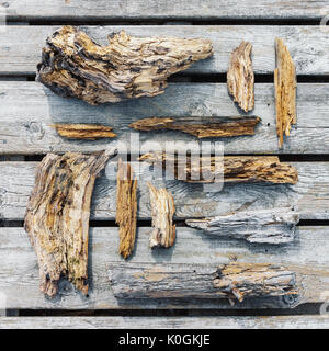 Old rotten wooden pieces and fragments well organized on wooden plank background, top view Stock Photo