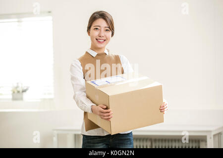 Young smiling woman with delivery box Stock Photo