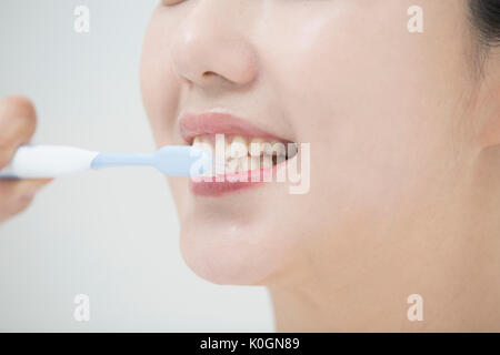Closeup of smiling woman brushing teeth Stock Photo