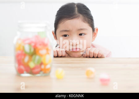 Portrait of girl watching candies in a jar Stock Photo