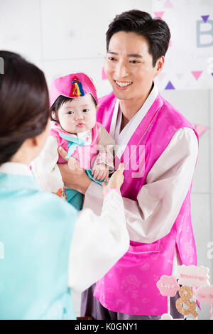 Smiling parents and baby daughter at first birthday party Stock Photo