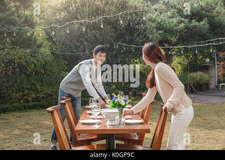 Young smiling couple preparing for a party at garden Stock Photo