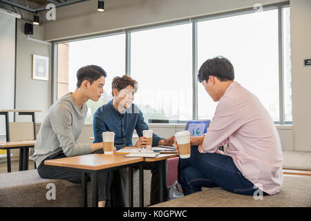 Three businessmen having a discussion at cafeteria Stock Photo