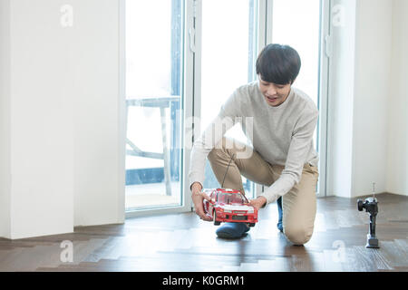 Smiling man kidult playing with toy car Stock Photo
