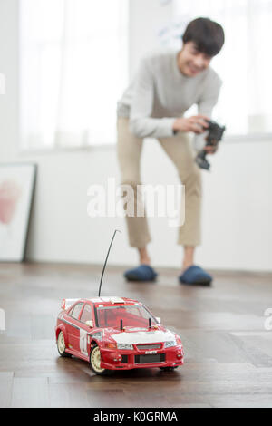 Smiling male kidult playing with toy car Stock Photo