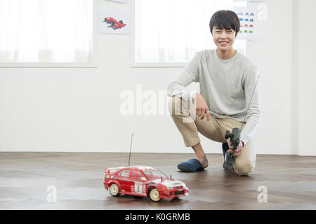 Smiling male kidult playing with toy car Stock Photo