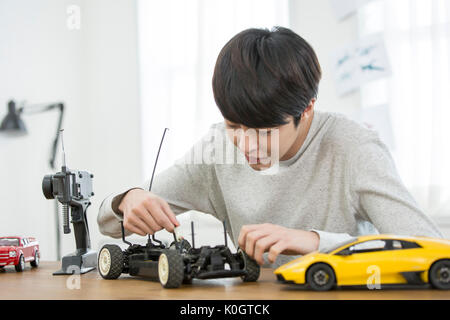 Portrait of smiling male kidult playing with toy cars Stock Photo