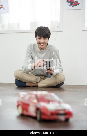 Smiling male kidult playing with toy car Stock Photo
