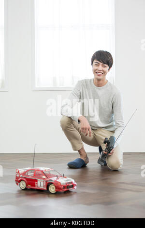 Smiling male kidult playing with toy car Stock Photo