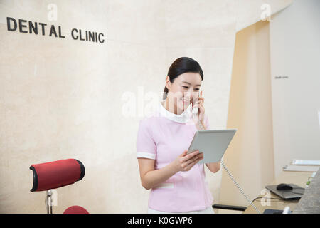 Smiling female dental hygienist talking on the phone Stock Photo