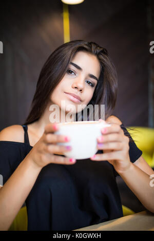 Woman with cup of tea has a rest at the coffee bar Stock Photo