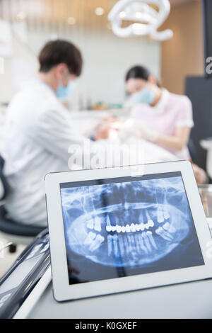 Dentist and dental hygienist curing a patient Stock Photo