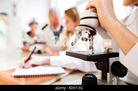 Unrecognizable high school student with microscope in laboratory Stock Photo