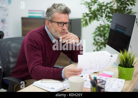 Hardworking man reading some important documents Stock Photo