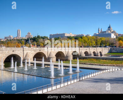 Puente de Segovia sobre el río Manzanares en el parque de Madrid Río. Catedral de la Almudena, Palacio Real y Rascacielos de Plaza de España al fondo. Stock Photo