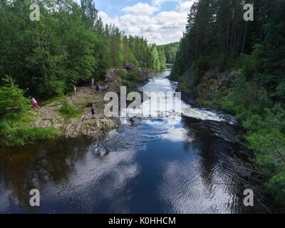 KARELIA, RUSSIA-CIRCA JUL, 2017: Children and adults are on rocky riverbed of the Kivach Fall on the river Suna. The Kivach is a state nature reserve  Stock Photo