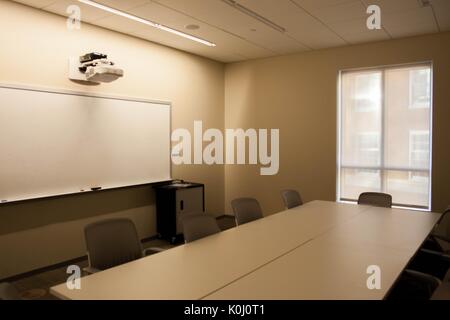 A study room of Brody Learning Commons with a large empty white table surrounded by grey tables, a whiteboard, and a window with its blinds not drawn, 2016. Courtesy Eric Chen. Stock Photo