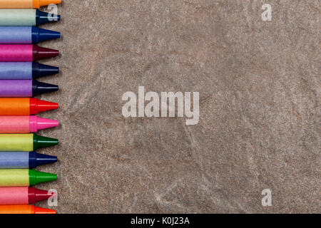 Natural stone background with a wax colouring crayon left hand border Stock Photo