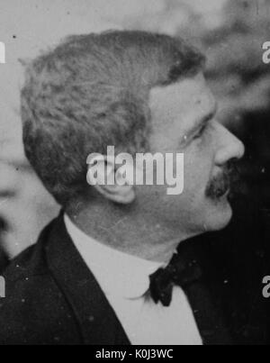 Head shot of original faculty member of Johns Hopkins University Medicine, Henry Mifflin Thomas, wearing a dark suit, a white shirt, and a bow-tie, looking upwards and to the left, with a serious facial expression. 1905. Stock Photo