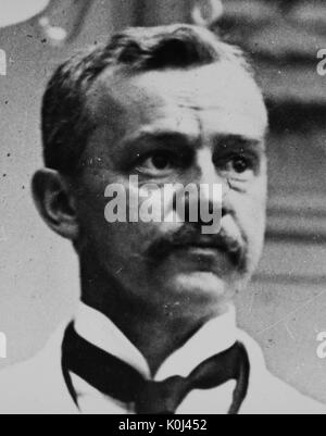 Head shot of original faculty member of Johns Hopkins University Medicine, Howard Atwood Kelly, wearing a white shirt and a white suit with a black tie, with a serious facial expression. 1905. Stock Photo