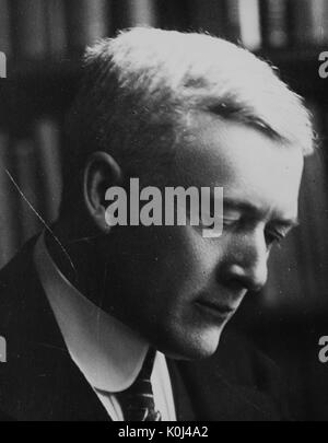 Head shot of original faculty member of Johns Hopkins University Medicine, Franklin Lewellys Baker, wearing a dark suit and a striped tie with a white shirt, looking downwards with a serious facial expression, posed in front of a bookshelf. 1915. Stock Photo