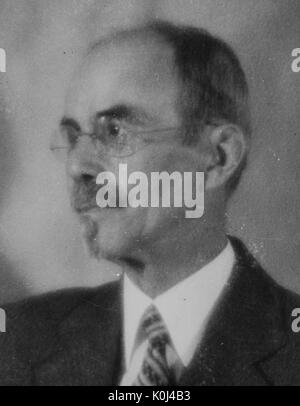 Head shot of John Jacob Abel, an original faculty member of Johns Hopkins University Medicine, wearing a dark suit and a striped tie with a white shirt, wearing circular frameless glasses, looking to his right, posed in front of a backdrop, with a serious facial expression. 1931. Stock Photo