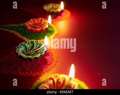 Diwali oil lamp - Diya lamp lit on colorful Rangoli Stock Photo