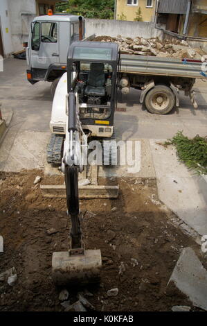 Bulldozer digging in the yard and truck waiting to transport Stock Photo