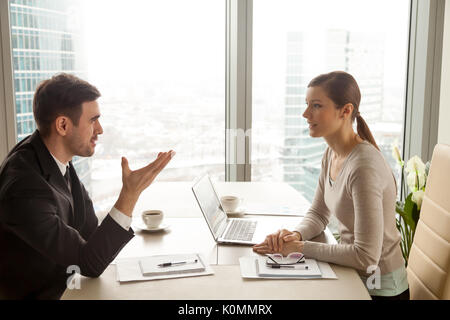 Businessman and businesswoman discussing work at office desk nea Stock Photo