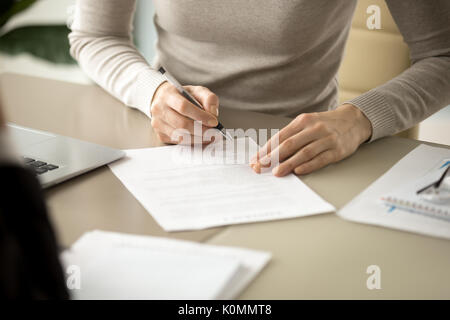 Woman signing document, focus on female hand putting signature,  Stock Photo