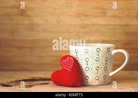 Coffee in a cup, with small red heart, on wooden background Stock Photo