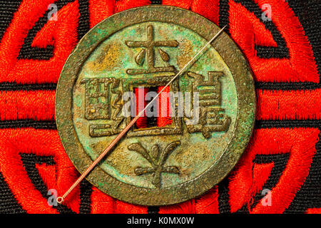 acupuncture needle on Chinese coin and symbol for imortality Stock Photo