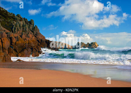 A view of Porthcurno beach as waves crash against the cliffs Stock Photo