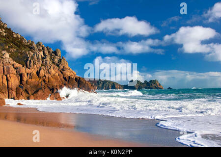 A view of Porthcurno beach as waves crash against the cliffs Stock Photo