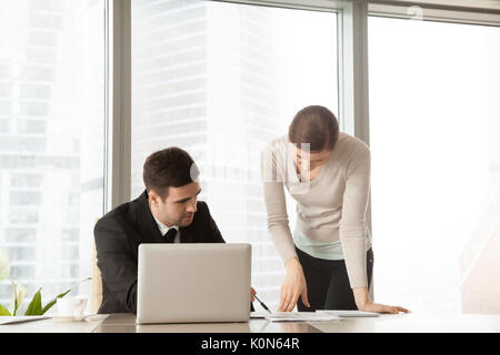 Serious boss explaining project to assistant, architects discuss Stock Photo