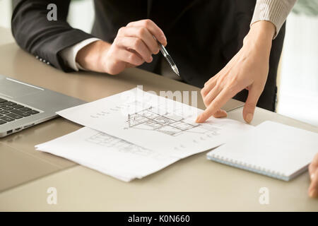 Architects discussing two-story house building plan, property ap Stock Photo
