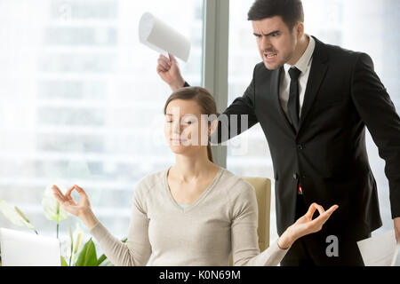 Calm attractive businesswoman meditating in office, ignoring ang Stock Photo