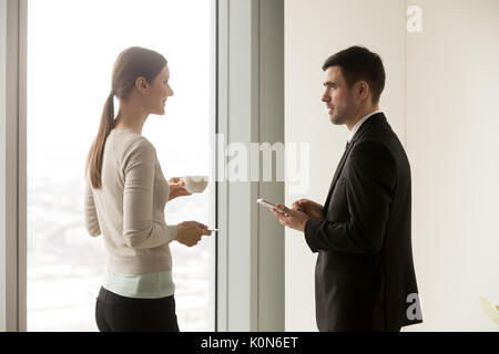 Smiling business team members talking in office during coffee br Stock Photo