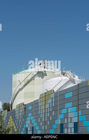 Two chemical tanks in front of colored soundproof wall Stock Photo