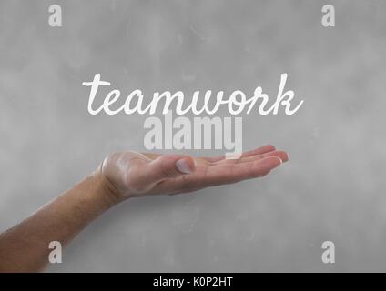 Digital composite of Hand interacting with teamwork business text against grey background Stock Photo