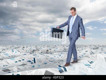 Digital composite of Businessman holding briefcase balancing in sea of documents under sky clouds Stock Photo