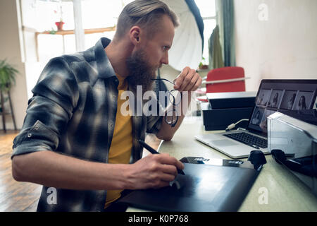 Photographer using graphic tablet  while editing picture Stock Photo