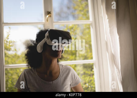 Woman using virtual reality headset at home Stock Photo