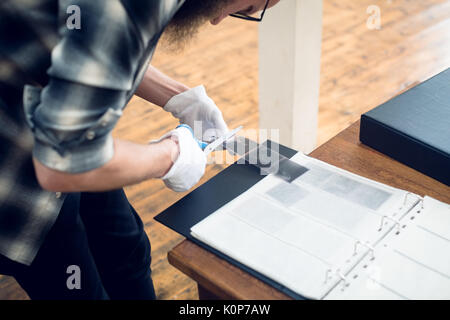 High angle view of photographer cutting film reel while working in studio Stock Photo